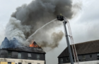 Baby among five rescued from home as fire tears through roof of flats